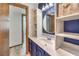 Stylish bathroom with blue accents, a round mirror, and ample storage space at 536 Greenbriar Pl, Boulder City, NV 89005