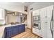 Kitchen with stainless appliances, modern vent hood and blue cabinets, open to dining area at 536 Greenbriar Pl, Boulder City, NV 89005