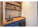 Stylish wet bar with wood countertop, shelving, a sink, and a mini fridge at 536 Greenbriar Pl, Boulder City, NV 89005