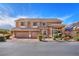 Two-story home showcasing a three-car garage, manicured landscaping, and a welcoming entrance at 5868 Revital Ct, Las Vegas, NV 89131