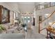 Bright living room with high ceilings, neutral tones, elegant furnishings, and a staircase at 5868 Revital Ct, Las Vegas, NV 89131