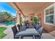 Covered patio featuring an outdoor dining area with lush landscaping and a pool view at 5868 Revital Ct, Las Vegas, NV 89131