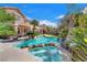 Beautiful backyard featuring a sparkling pool with a spa, lush landscaping, and a patio area at 5868 Revital Ct, Las Vegas, NV 89131