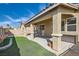 Wide view of backyard with covered patio and low maintenance artificial turf at 6035 Eganridge Ct, North Las Vegas, NV 89081