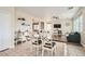 Bright dining area featuring tile floors, a dark wood table, and white chairs near the living area at 6035 Eganridge Ct, North Las Vegas, NV 89081