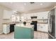 Well-lit kitchen featuring white cabinets, a center island with a light green base, and stainless steel appliances at 6035 Eganridge Ct, North Las Vegas, NV 89081