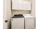 Modern laundry room with upper cabinets and washer and dryer at 6035 Eganridge Ct, North Las Vegas, NV 89081