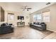 Cozy living room with large windows, hardwood floors, ceiling fan, and a comfortable couch and loveseat at 6035 Eganridge Ct, North Las Vegas, NV 89081