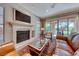 Cozy living room showcasing a fireplace with stone surround, a large television, and sliding glass doors at 65 Luce Del Sole # 1, Henderson, NV 89011