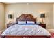 Main bedroom featuring a decorative headboard, two nightstands, and hardwood flooring at 65 Luce Del Sole # 1, Henderson, NV 89011