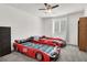 Themed bedroom designed with stylish car-shaped beds, a ceiling fan and a bright window at 6618 Palm Branch St, North Las Vegas, NV 89086