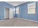 Bedroom with blue walls, two large windows with blinds, and a closet at 6832 Upland Heights Ave, Las Vegas, NV 89142