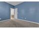 Bedroom with blue walls, neutral carpet, and a door to the en-suite bathroom at 6832 Upland Heights Ave, Las Vegas, NV 89142