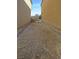 Narrow side yard featuring dirt and gravel between two homes with a gate at the end at 7325 Sunray Point St, North Las Vegas, NV 89084