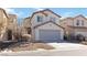 Beige two-story home featuring a two-car garage and low-maintenance desert landscaping at 7452 Wine Creek St, Las Vegas, NV 89139