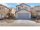 Beige two-story home featuring a two-car garage and low-maintenance desert landscaping at 7452 Wine Creek St, Las Vegas, NV 89139