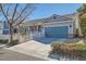 Lovely home with a blue garage door and a white picket fence surrounding the front yard at 7835 Meandering Path Ave, Las Vegas, NV 89131