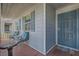 Cozy front porch seating with blue cushions and a secure screen door entrance at 7835 Meandering Path Ave, Las Vegas, NV 89131