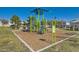 Community playground with colorful play structure on woodchips, with seating, in a grassy, fenced area at 7835 Meandering Path Ave, Las Vegas, NV 89131