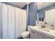 Cozy blue bathroom with a shower featuring sleek fixtures and a white shower curtain at 9037 Wolf Dancer Ave, Las Vegas, NV 89143