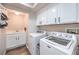 Efficient laundry room with modern washer and dryer, storage cabinets, and a utility sink at 9037 Wolf Dancer Ave, Las Vegas, NV 89143