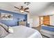 Bedroom with a barn door to the bathroom, a ceiling fan, and neutral-toned decor at 9037 Wolf Dancer Ave, Las Vegas, NV 89143