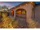 Covered patio with arched openings, complemented by desert landscaping, an outdoor chair, and inviting lighting at 9091 Becket Ranch Ct, Las Vegas, NV 89113