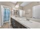 Modern bathroom features double vanity with stone countertop and neutral color palette at 9091 Becket Ranch Ct, Las Vegas, NV 89113