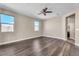 Bright bedroom featuring hardwood floors, ceiling fan, and dual windows at 9091 Becket Ranch Ct, Las Vegas, NV 89113