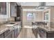 Modern kitchen with stainless steel appliances, granite countertops, dark wood cabinets, and eat-in dining area at 9091 Becket Ranch Ct, Las Vegas, NV 89113