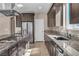 Bright kitchen with stainless steel refrigerator, dark cabinets, granite countertops, and a central island at 9091 Becket Ranch Ct, Las Vegas, NV 89113