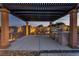 Outdoor kitchen with a large grill, bar seating, a pergola, and well-maintained backyard landscaping at 9091 Becket Ranch Ct, Las Vegas, NV 89113