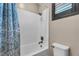 Shower with gray and white tiles, bronze fixtures, a shower curtain and a window with shutters at 9091 Becket Ranch Ct, Las Vegas, NV 89113