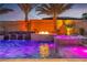 Backyard pool with a waterfall, a fire pit feature, and a spa illuminated with color-changing lights at 9091 Becket Ranch Ct, Las Vegas, NV 89113