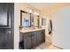 Bathroom featuring double vanity with black cabinetry, tile floors, and a large mirror at 9532 Cliff View Way, Las Vegas, NV 89117