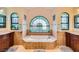 Bathroom showcasing an oversized tub, a large arched window, and dual sinks at 9532 Cliff View Way, Las Vegas, NV 89117