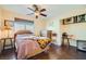 Bedroom featuring wood floors, ceiling fan, window, and minimal decor at 9532 Cliff View Way, Las Vegas, NV 89117