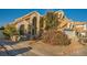 Two-story home featuring a stucco finish, arched windows, tile roof and low maintenance desert landscaping at 9532 Cliff View Way, Las Vegas, NV 89117