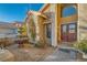 Charming front entrance with double doors, decorative fountain, and beautiful desert landscaping at 9532 Cliff View Way, Las Vegas, NV 89117