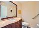 Well-lit powder room with a dark wood vanity, sink, mirror, and tiled countertop at 9532 Cliff View Way, Las Vegas, NV 89117