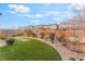 Landscaped backyard with artificial grass, plants, and a decorative bird bath, creating a tranquil outdoor space at 10438 Skye Arroyo Ave, Las Vegas, NV 89166