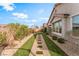 Beautifully landscaped backyard featuring artificial turf and a stone pathway leading through the garden at 10438 Skye Arroyo Ave, Las Vegas, NV 89166