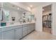 Bathroom boasts double sinks with modern hardware and a view into the spacious walk-in closet at 10438 Skye Arroyo Ave, Las Vegas, NV 89166