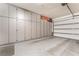 Spacious garage with storage cabinets and roll-up garage door, perfect for organization at 10438 Skye Arroyo Ave, Las Vegas, NV 89166