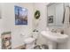 Stylish powder room with pedestal sink, decorative mirror, and modern accents at 10438 Skye Arroyo Ave, Las Vegas, NV 89166