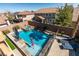 An aerial view showcases a sparkling pool and spa in a backyard, surrounded by patio space and lush greenery at 1138 Grove Park St, Henderson, NV 89002