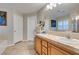 Bright bathroom features double sinks, neutral tile flooring, and a large framed mirror at 1138 Grove Park St, Henderson, NV 89002