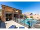 An inground pool is surrounded by stone tile and secured with a -safe fence, offering a perfect blend of leisure and safety at 1138 Grove Park St, Henderson, NV 89002