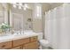 Cozy bathroom with white tiled walls, a wood cabinet sink, and shower with curtain at 1272 Olivia Pkwy, Henderson, NV 89011