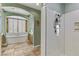 Bright bathroom features tiled floors, a soaking tub beneath shuttered windows, and a glass-enclosed shower at 1272 Olivia Pkwy, Henderson, NV 89011